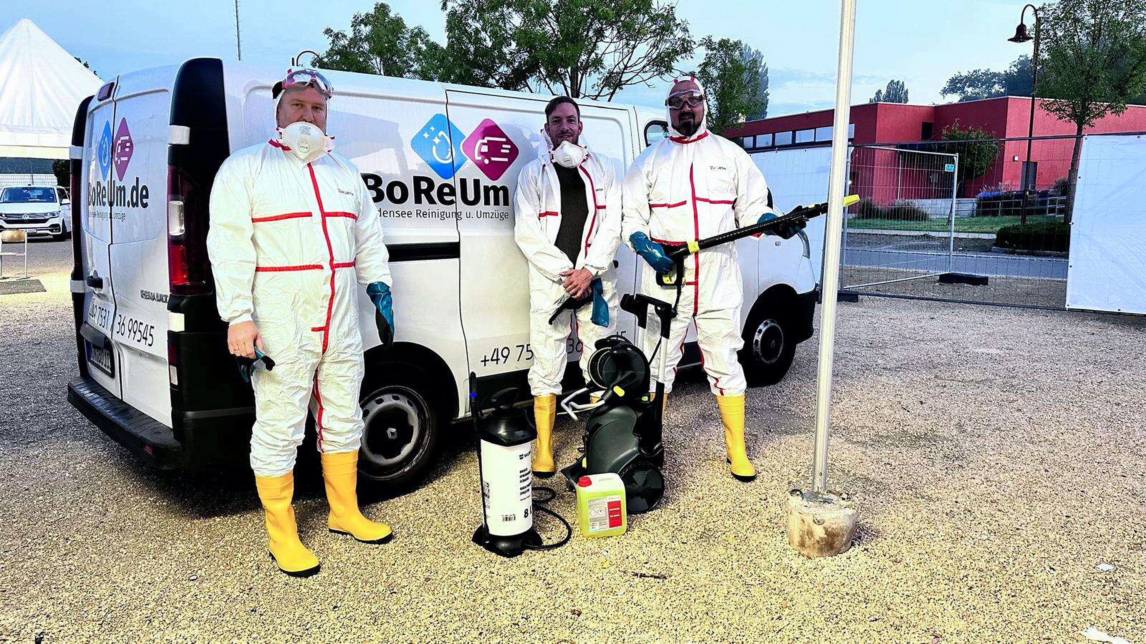 Vier Mitarbeiter in Schutzkleidung neben einem BoReUm-Fahrzeug