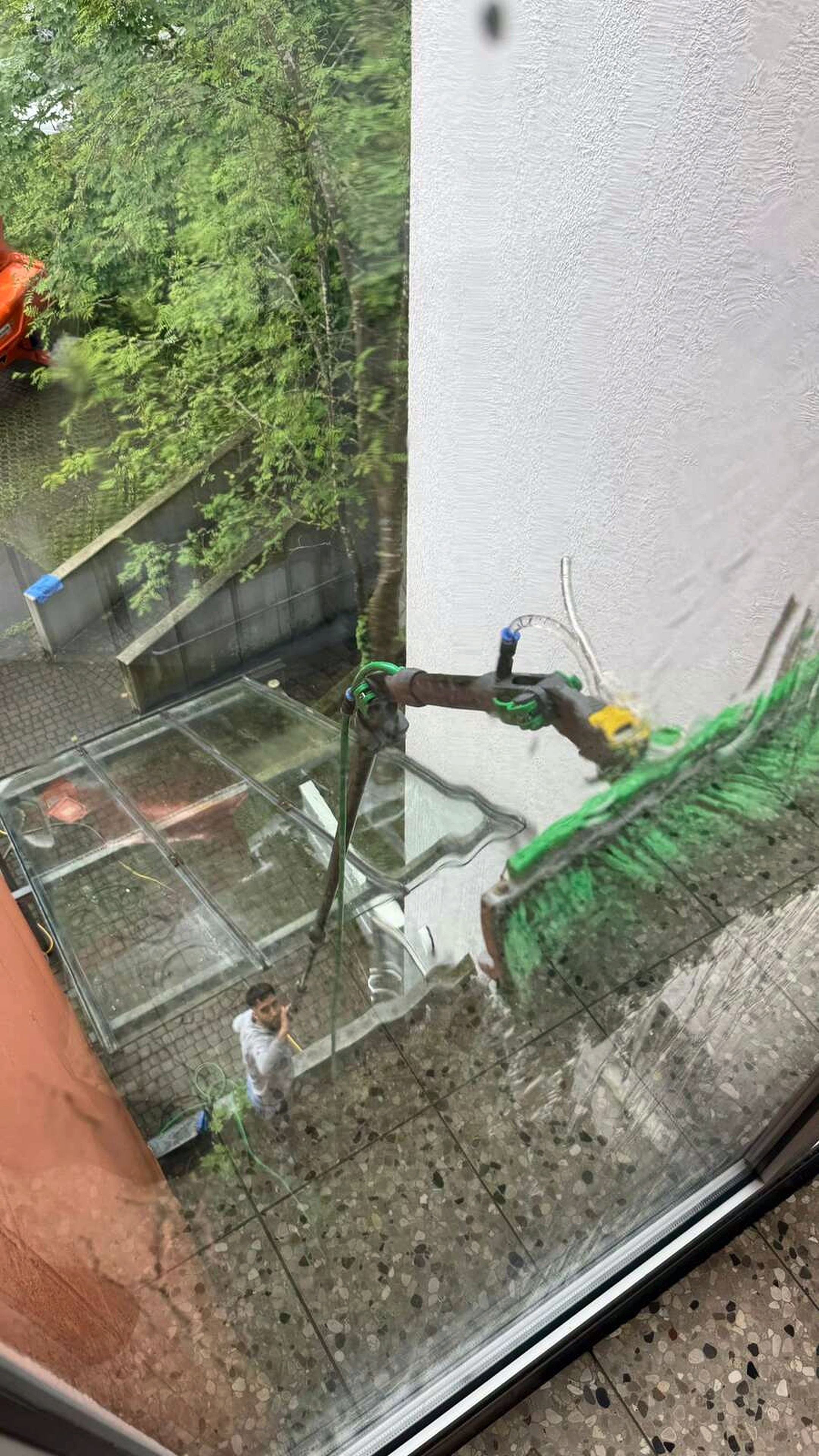 Mitarbeiter bei der Reinigung einer Glasfläche